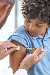 Vaccination. Young boy receiving vaccination immunisation by professional health worker, kid...