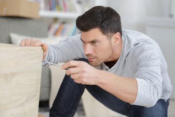 Fototapeta premium man screwing the furniture edges