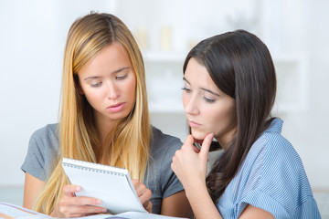 two female students studying together at home