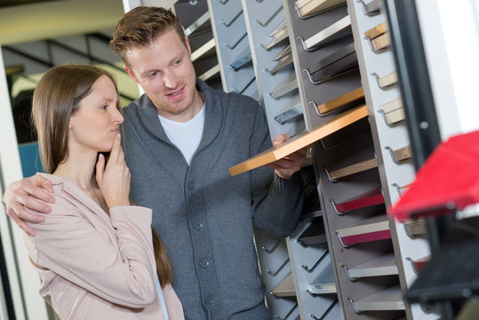 young couple standing in decoration store with tile color samples