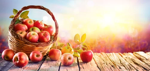 Zelfklevend Fotobehang Vruchten Rode appels in mand op oude tafel bij zonsondergang