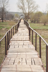Fototapeta premium vue avec vieux pont en bois sur lit de rivière avec arbres à la campagne