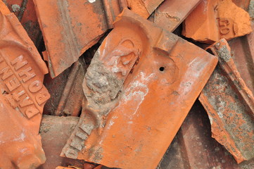 détail d'une pile de tuiles cassées en terracotta avec motifs et inscrits