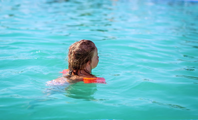 little girl swimming in outdoor pool and have a fun.