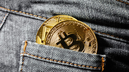 Golden Bitcoin coins in blue denim jeans pocket
