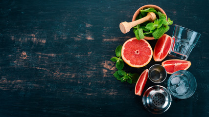 Preparation for preparing a cocktail of citrus fruit and mint. Lemon, grapefruit, lime, orange. On a wooden background. Top view.
