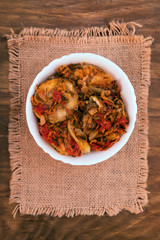 Vegetable light vegetarian appetizer of vegetables in white bowl on linen cloth napkin, top view on wooden background.