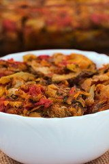 Vegetable stew in a white bowl, close-up, vertical frame.