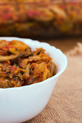 Vegetable snack in a porcelain white bowl on a cloth napkin, close-up vertical frame.