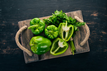 Fresh green pepper in a wooden box. Organic food. Top view. Free space for text.