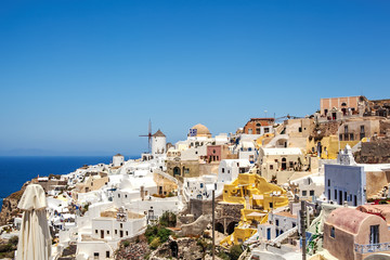 Fototapeta premium Most Romantic Greek Oia town on Santorini island, Greece. Traditional and famous houses and churches with blue domes over the Caldera, Aegean sea. Santorini classically Thera and officially Thira.
