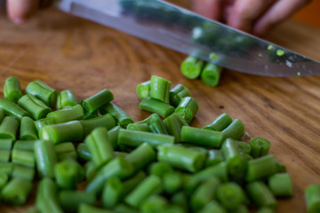 Coocking of green beans and garlic, fresh vegatables on wooden table