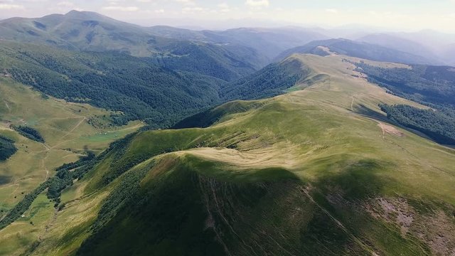 Aerial of a multiformed Carpathian range with fuzzy cloud shades in summer