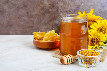 Honey in a glass jar, honeycomb, pollen. Products of beekeeping. The concept of healthy eating.