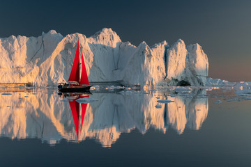 Greenland midnight Sunset iceberg perfect reflection panorama with red sail ship  - obrazy, fototapety, plakaty