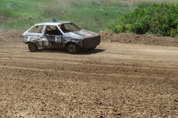 Fototapeta na wymiar Race of the old wrecked cars. Rally on the open air with dust
