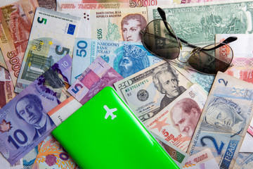 Passport cover with symbol of plane and shades on world currencies cash money background. travel worldwide concept