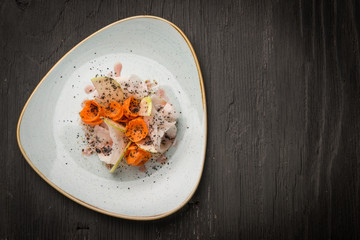 Top view of vegan salad made of carrots and radish decorated with truffle