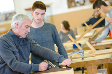 carpenter with apprentice in training period