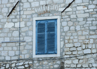 Obraz na płótnie Canvas Blue wooden window and stone Mediterranean house 