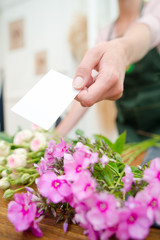 Obraz premium Florist holding card to accompany flowers