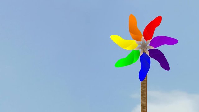 VIBGYOR Coloured Spinning Pin wheel against cloudy Sky animated video footage
