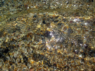 Texture from nature. Whirlpool of transparent sea water over multicolored pebbles.		This is an abstract look at the sea, but you can recognize in it a human face.