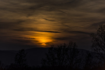 Fototapeta na wymiar Dark sunset with the disc of sun. Dark and scary atmosphere.