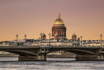 Fototapeta na wymiar View of the Annunciation bridge across the Neva river and the dome of St. Isaac's Cathedral at sunset. Saint Petersburg, Russia
