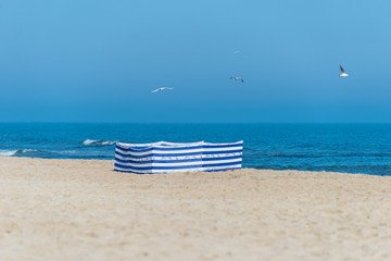 Beach screen on the Polish beach on a sunny summer day in the background beautiful sea and flying gulls.