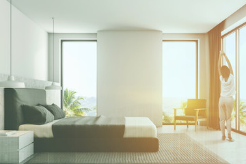 Luxury white bedroom interior, side view, woman