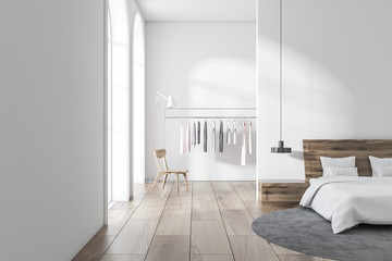 White bedroom interior, clothes rack