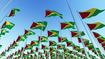 3d flags of Guyana waving in the wind against blue sky. Three dimensional rendering animation.