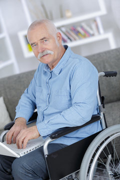 mature businessman in a wheelchair working on a laptop