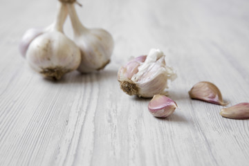 Garlic bulbs on white wooden table, side view. Close-up.