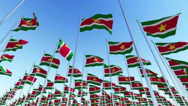 Many National Flags of Suriname, South America against blue sky.  Three dimensional rendering 3D animation.