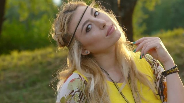 portrait of a young blonde woman with hippies. a woman with braided hair. A warm summer day and soft backlight. happy woman is dancing. the middle plan. a hot summer day. HD slowmotion