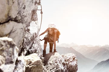 Foto op Aluminium Woman wearing gear hiking up rocky cliff side © XtravaganT