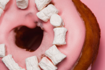 Pink donut with marshmallows on a Pink background