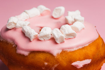 Pink donut with marshmallows on a Pink background
