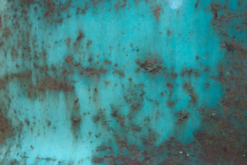 Beautiful natural background from an old, rusty, iron barrel. Rusted iron with the remains of turquoise paint.