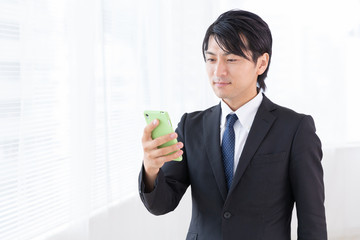 スマホを見るミドル男性　ビジネス