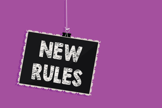 Text sign showing New Rules. Conceptual photo A state of changing an iplemented policy for better upgrade Hanging blackboard message communication information sign purple background.