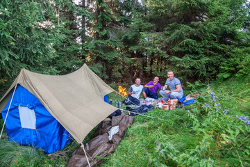 Tourists near the fire, rest in the Carpathian Mountains.