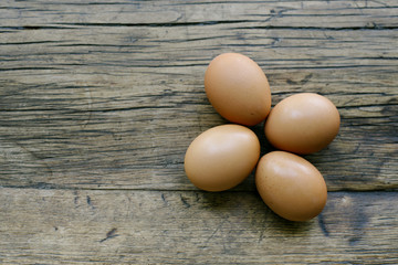 Top view of 4 fresh eggs on a farm table with copy space