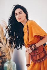 Portrait of beautiful girl in the orange clothing of style of boho