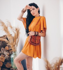 Portrait of beautiful girl in the orange clothing of style of boho