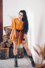 Portrait of beautiful young in the orange clothing of style of boho