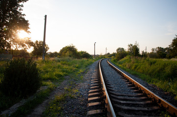 Obraz premium railway tracks lead to the station on a summer