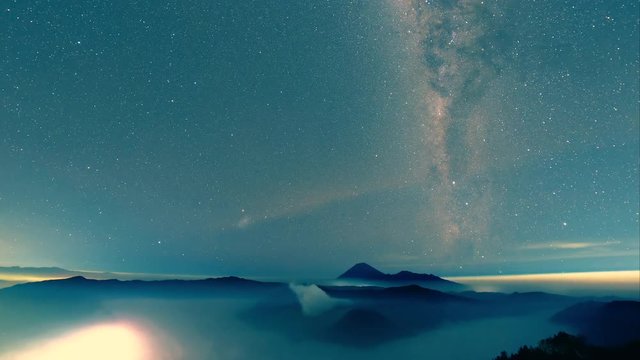 Milkyway galaxy moving from left to right over misty Bromo-Tengger-Semeru National Park a time-lapse video clip